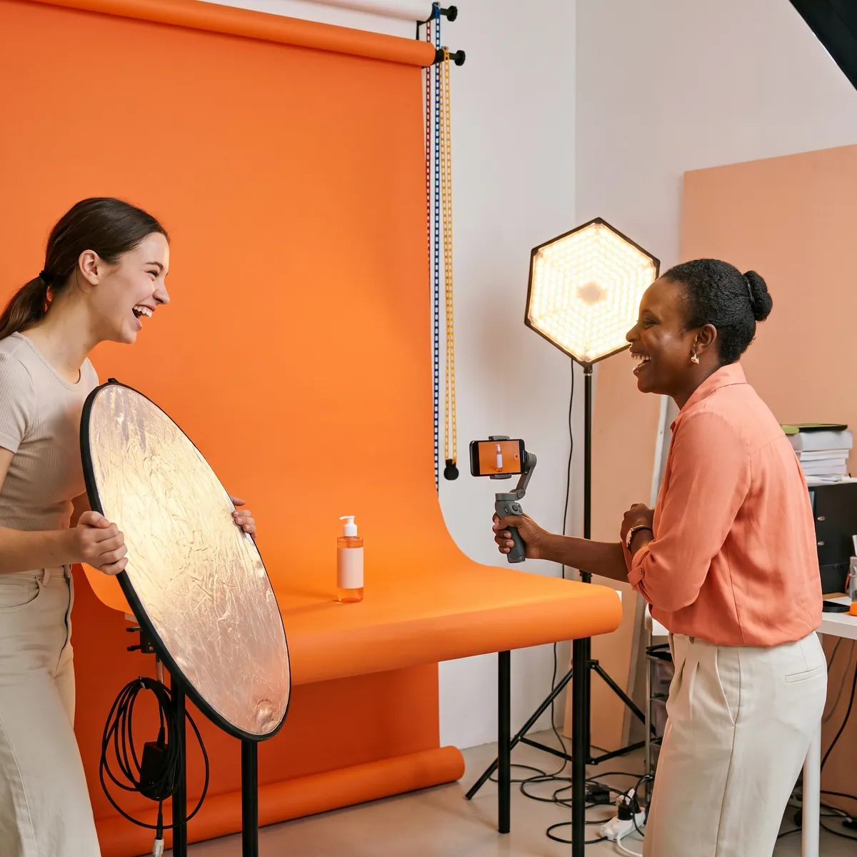 A creator filming a product for a scheduled post on a tangerine backdrop